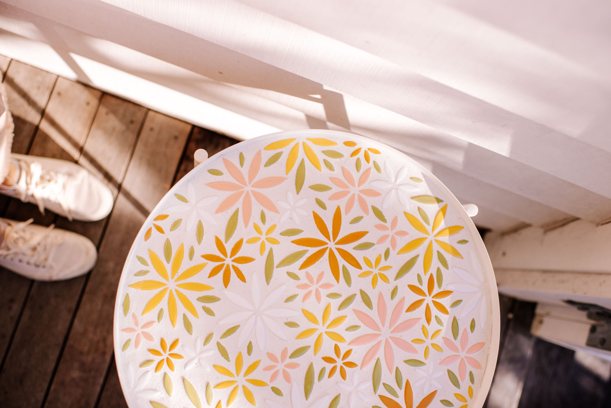 Table customisée avec de la mosaique sur le plateau et formant un motif de fleurs pastels