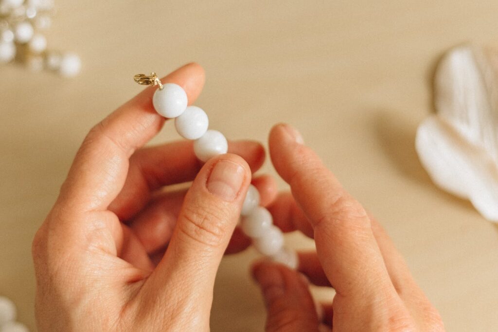 Person Holding White Pearl Beads