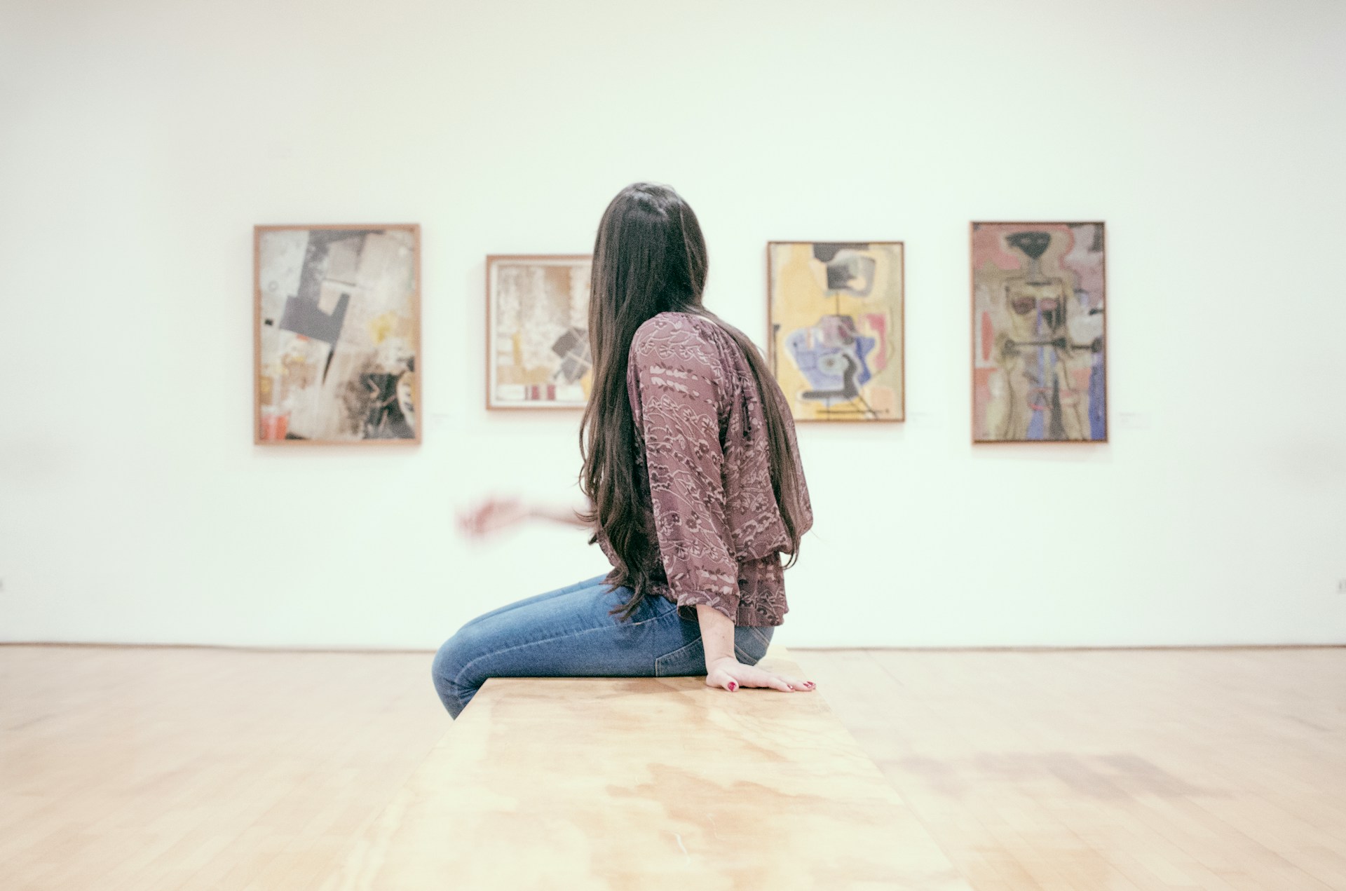 Jeune femme observant des oeuvres dans un musée.